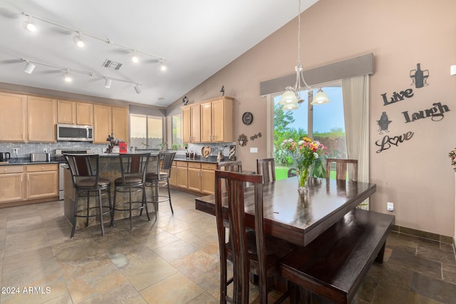 dining room with high vaulted ceiling and an inviting chandelier