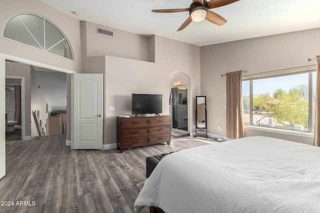 bedroom with ceiling fan, a high ceiling, and hardwood / wood-style flooring