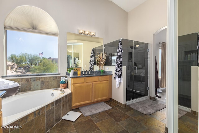 bathroom featuring high vaulted ceiling, vanity, and plus walk in shower