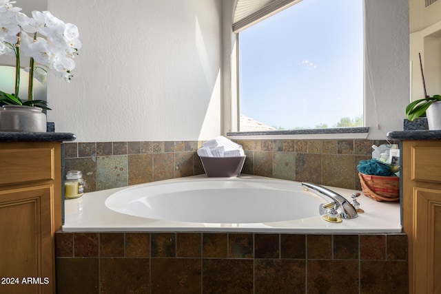 bathroom featuring vanity and tiled tub