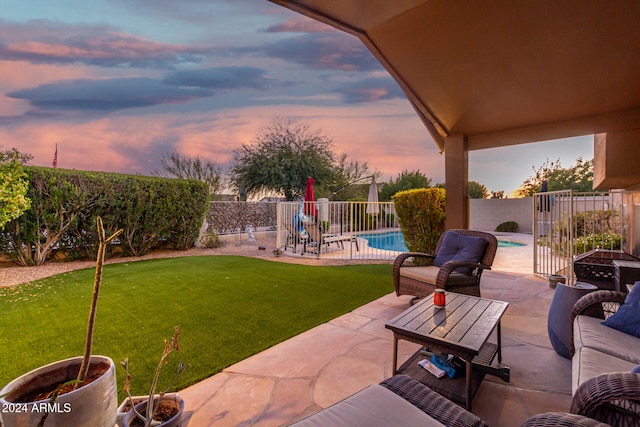 patio terrace at dusk featuring a fenced in pool and a yard