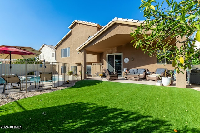 rear view of property with a yard, an outdoor living space, and a patio area