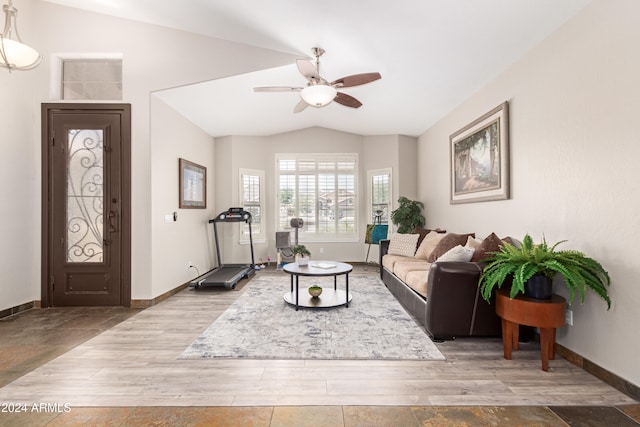 living room featuring ceiling fan, light hardwood / wood-style flooring, and vaulted ceiling