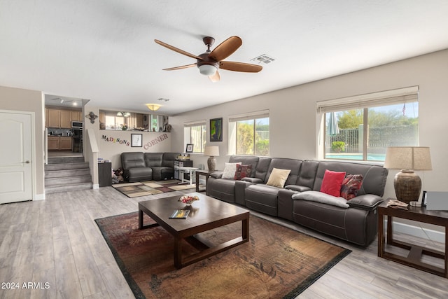 living room featuring light hardwood / wood-style flooring and ceiling fan