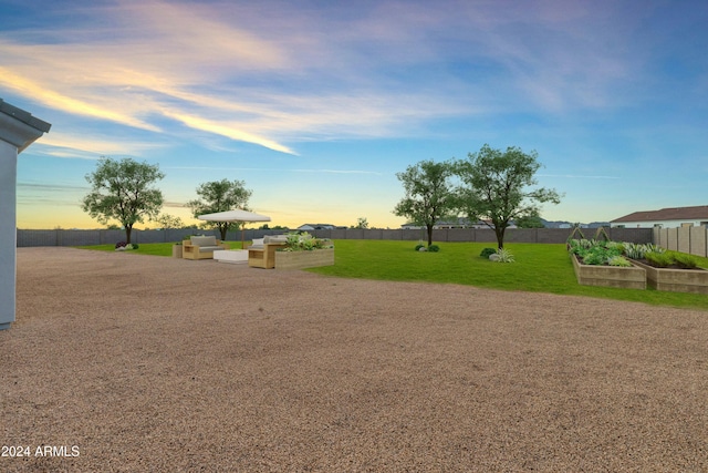 yard at dusk with a garden and fence