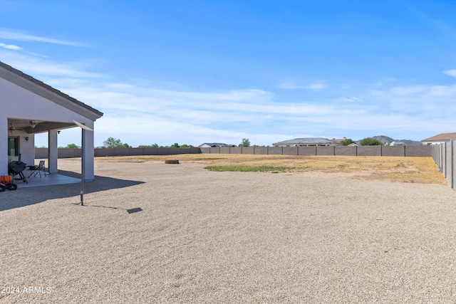 view of yard with a ceiling fan, a patio area, and a fenced backyard