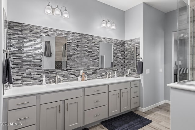 full bathroom with decorative backsplash, double vanity, wood finished floors, and a sink