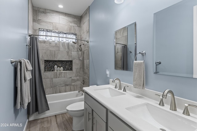 bathroom with a sink, toilet, wood finished floors, and shower / tub combo