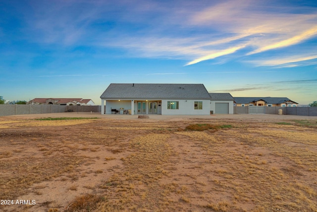 rear view of house featuring a patio area, a garage, and fence