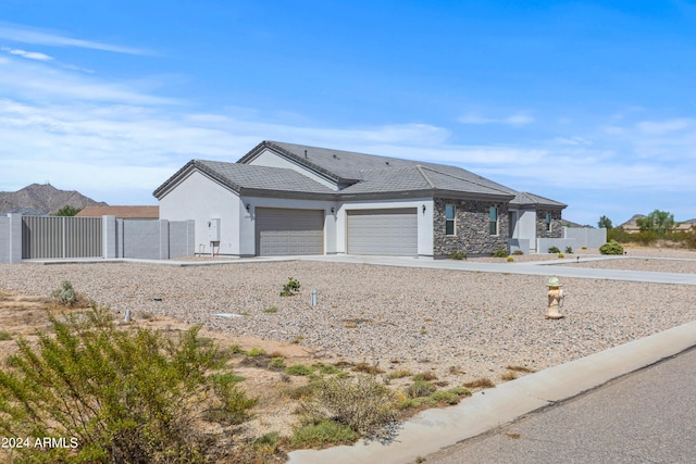 ranch-style house with stucco siding, a gate, fence, concrete driveway, and a garage