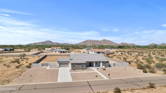 view of front of house featuring a mountain view, a garage, fence private yard, and concrete driveway