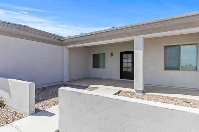 doorway to property with a patio area and stucco siding