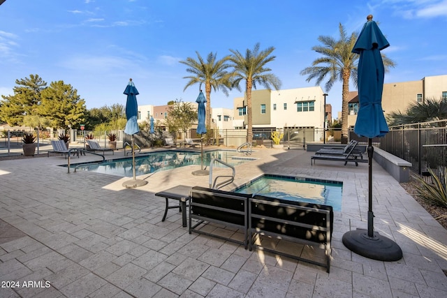 view of swimming pool featuring a community hot tub and a patio