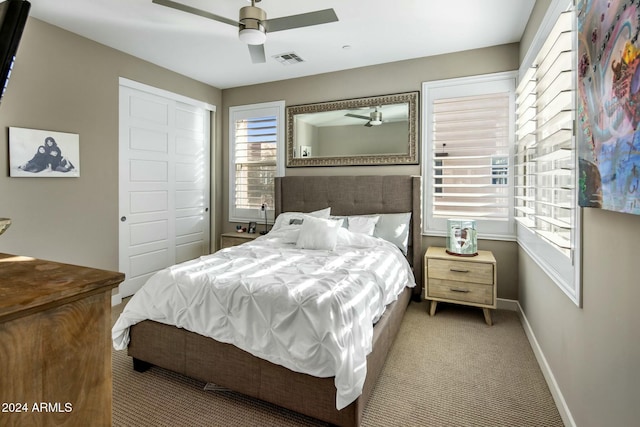 carpeted bedroom featuring ceiling fan and a closet