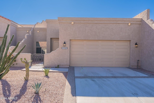 pueblo revival-style home with a garage