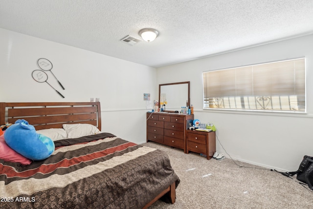 bedroom featuring a textured ceiling, carpet floors, and visible vents