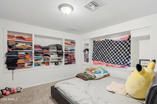 carpeted bedroom featuring visible vents and a textured ceiling