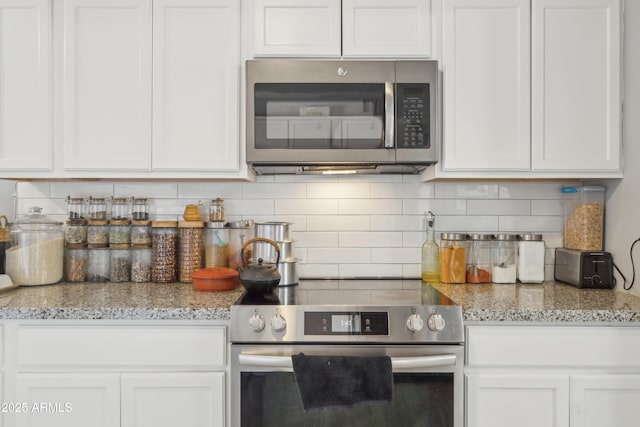 kitchen with stainless steel appliances, decorative backsplash, light stone countertops, and white cabinets