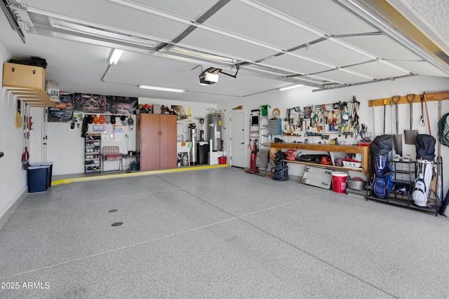 garage featuring a garage door opener, electric water heater, and a workshop area