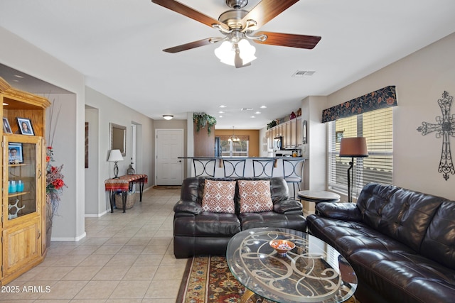 tiled living room with a healthy amount of sunlight and ceiling fan