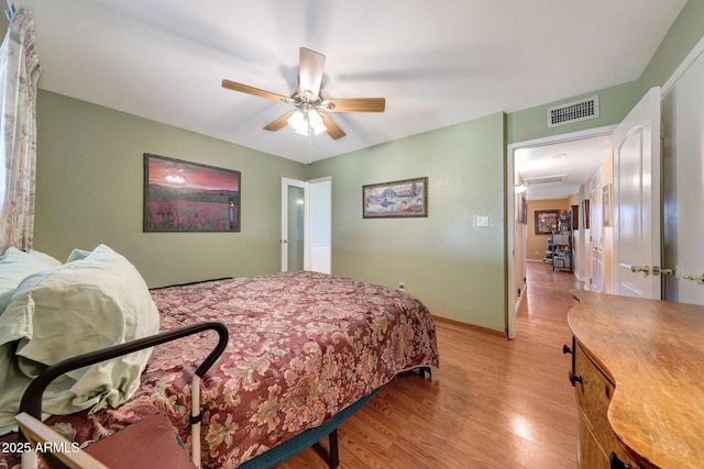 bedroom featuring light wood-style floors, a ceiling fan, and baseboards