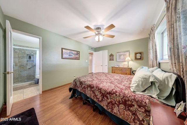 bedroom featuring light wood-type flooring, baseboards, connected bathroom, and a ceiling fan