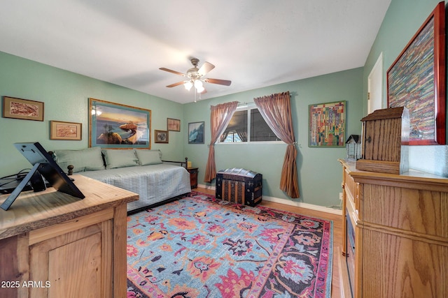 bedroom with wood finished floors, baseboards, and ceiling fan