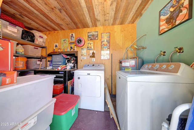 laundry room with wood ceiling, water heater, washing machine and dryer, and wooden walls