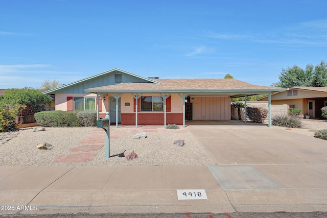single story home featuring an attached carport, concrete driveway, covered porch, brick siding, and fence