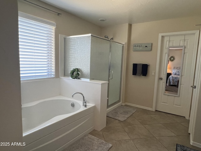 bathroom featuring a bath, baseboards, a shower stall, and tile patterned flooring