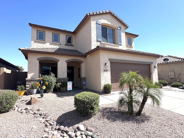 view of front facade with a garage, stucco siding, driveway, and a tile roof