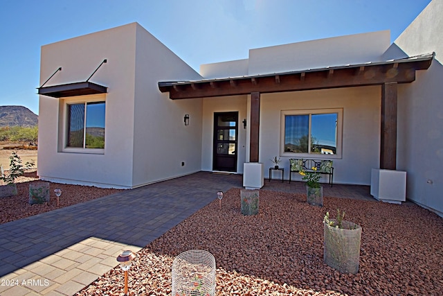 view of front of property with a patio and a mountain view