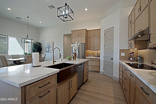 kitchen with a large island with sink, sink, light wood-type flooring, dishwasher, and a chandelier