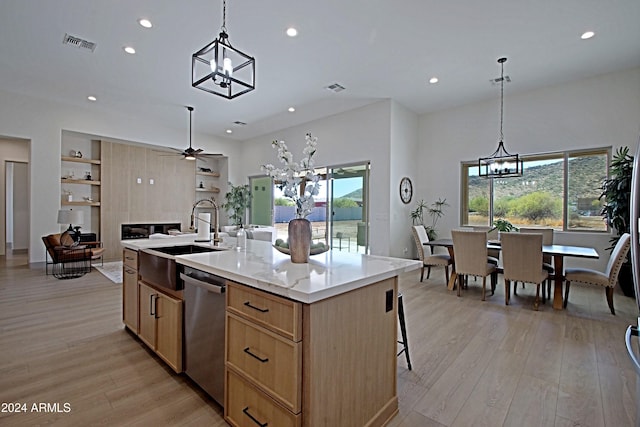 kitchen featuring sink, an island with sink, light hardwood / wood-style flooring, and ceiling fan with notable chandelier