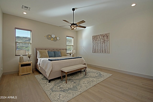 bedroom featuring multiple windows, light hardwood / wood-style floors, and ceiling fan