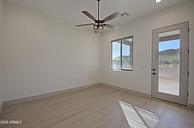 interior space featuring a mountain view, light hardwood / wood-style floors, and ceiling fan