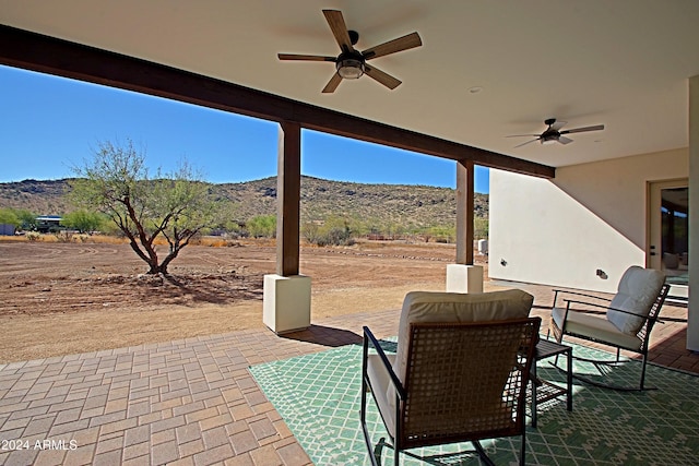 view of patio / terrace with a mountain view and ceiling fan