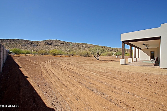 view of yard with a mountain view and ceiling fan