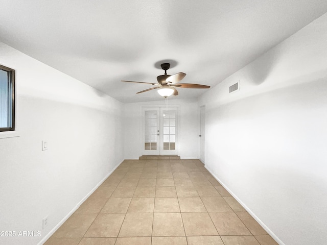 unfurnished room featuring visible vents, a ceiling fan, french doors, light tile patterned floors, and baseboards