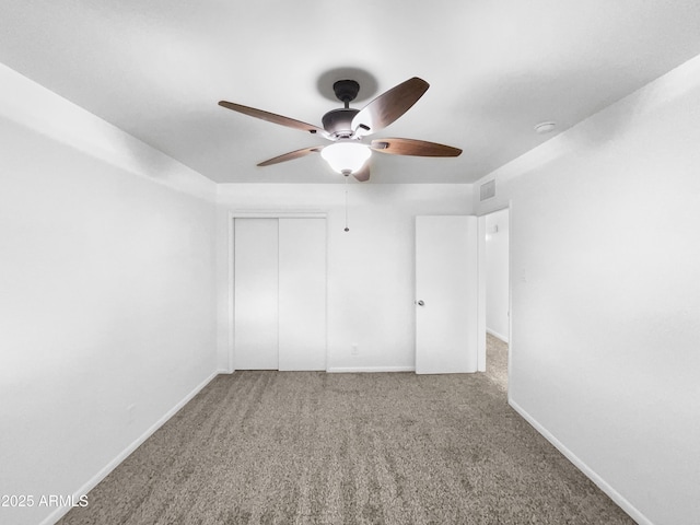 unfurnished bedroom with visible vents, a closet, carpet, baseboards, and ceiling fan