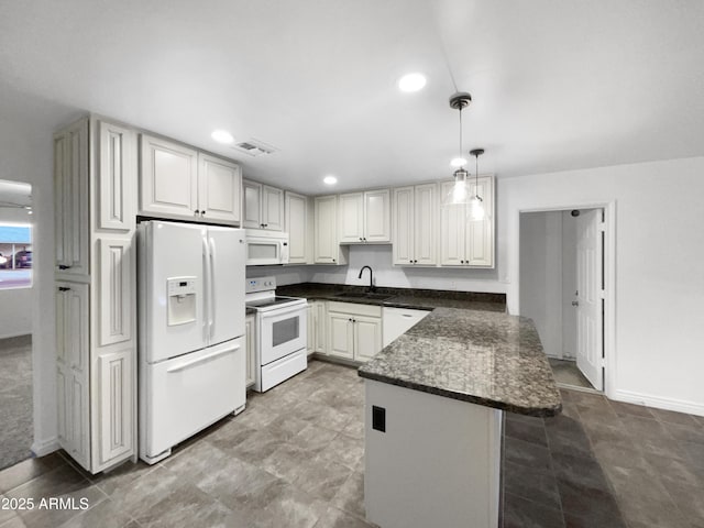 kitchen with white appliances, visible vents, a peninsula, a sink, and hanging light fixtures