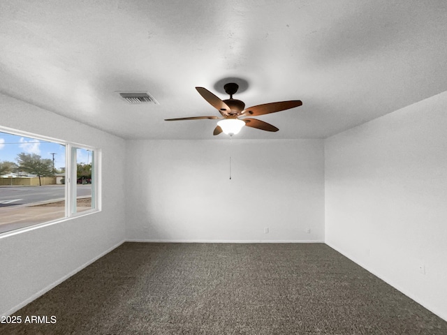 carpeted empty room featuring a ceiling fan and visible vents