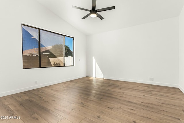 unfurnished room with lofted ceiling, baseboards, a ceiling fan, and wood finished floors