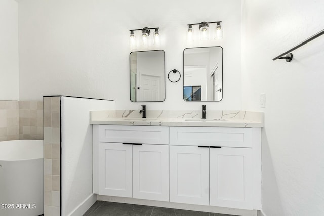 full bath featuring double vanity, a freestanding tub, and a sink