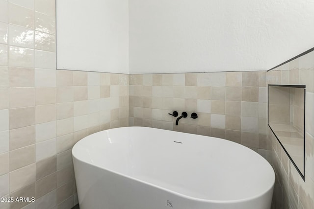 full bathroom with a freestanding bath and tile walls