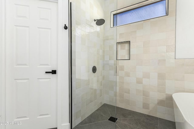 bathroom with a soaking tub, tile patterned flooring, and tiled shower