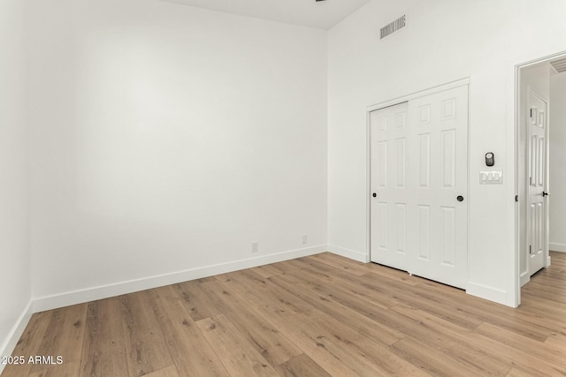 interior space featuring light wood-type flooring, visible vents, and baseboards