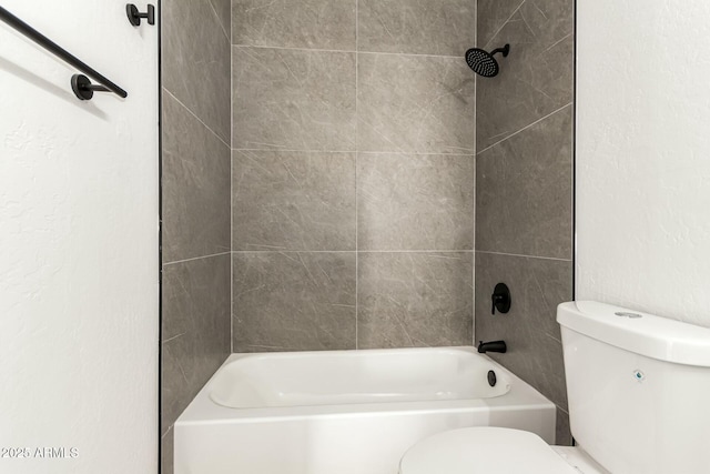 full bath featuring toilet and a textured wall