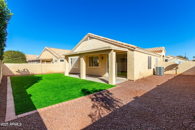 rear view of house with a patio, a fenced backyard, central AC, a yard, and stucco siding