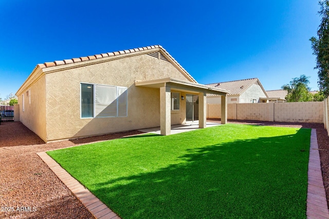 rear view of property featuring a patio, a lawn, a fenced backyard, and stucco siding